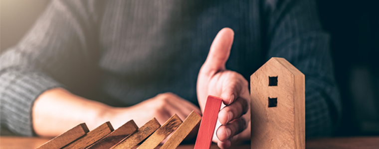 man holding up blocks protecting house